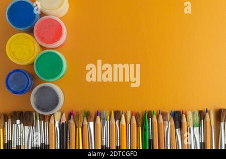 Collage of pencils and paints. Pencils and paints for drawing. The composition of pencils and paints. Brushes and pencils on the table. Drawing set Stock Photo