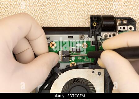 The master removes the cover on the computer with a screwdriver to repair computer equipment Stock Photo