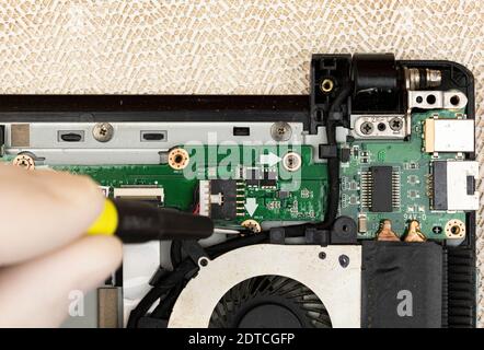The master removes the cover on the computer with a screwdriver to repair computer equipment Stock Photo