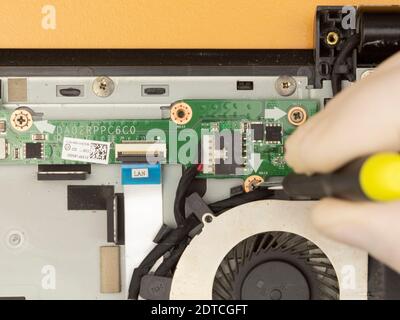 The master removes the cover on the computer with a screwdriver to repair computer equipment Stock Photo