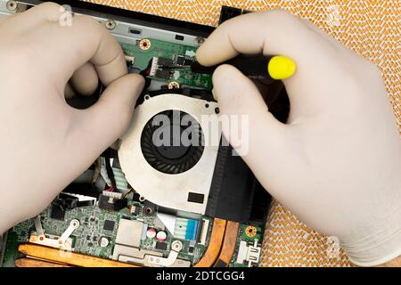 The master removes the cover on the computer with a screwdriver to repair computer equipment Stock Photo