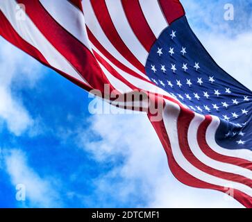 American flag blowing in wind against sky Stock Photo