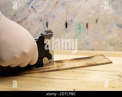 Man fastens boards with a stapler Stock Photo