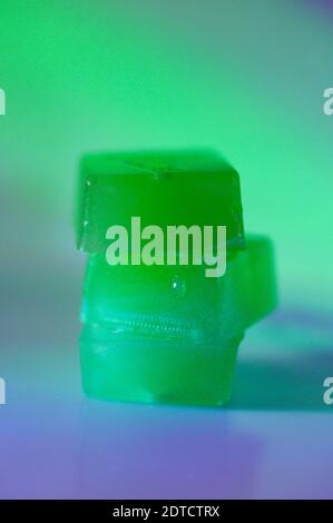 Stack of edible cannabis gummies in green light Stock Photo