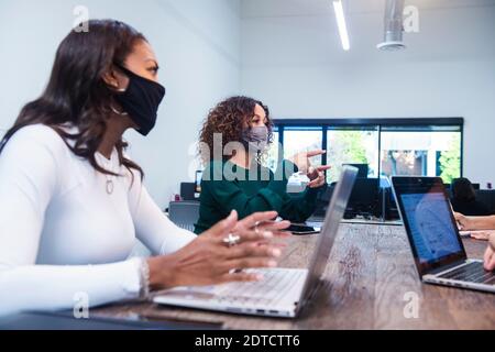 People in face masks having meeting in office Stock Photo