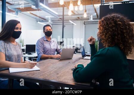 People in face masks having meeting in office Stock Photo