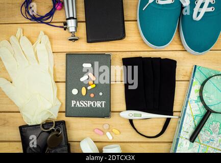 Items for travel and virus protection laid out on a wooden background Stock Photo