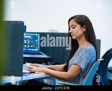 Woman using computer at desk in office Stock Photo