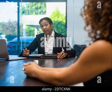 Two businesswomen at conference table Stock Photo