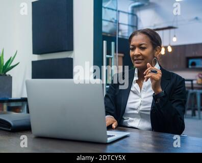 Businesswoman working on laptop at desk in office Stock Photo