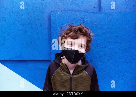 Boy (8-9) wearing protective face mask Stock Photo