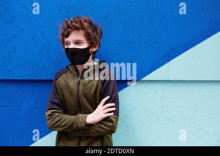 Boy (8-9) wearing protective face mask Stock Photo