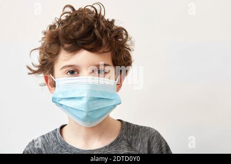 Boy (8-9) wearing protective face mask Stock Photo