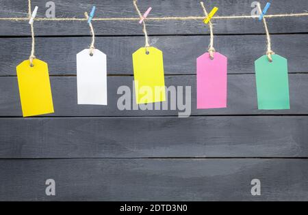 Colored clothespins and labels are hung on a rope. Multi-colored tags are hung on a scourge. Frame for text Stock Photo