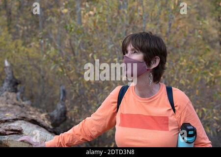 WOMAN HIKER WITH FACE MASK, BANDELIER NATIONAL MONUMENT, NM, USA Stock Photo