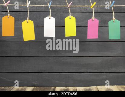 Colored tags are hung on a rope. Labels hanging on a rope with colored clothespins Stock Photo