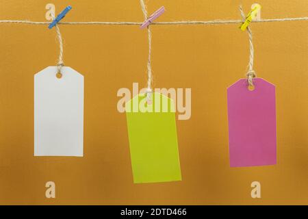 Colored tags are hung on a rope. Labels hanging on a rope with colored clothespins Stock Photo