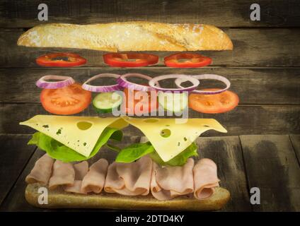 Flying burger. Hamburger or cheeseburger flying ingredients over a stone cutting board. Burger in the air. Place for text Stock Photo