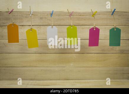 Labels hang on a rope with colored clothespins. Colored tags are hung on a rope Stock Photo