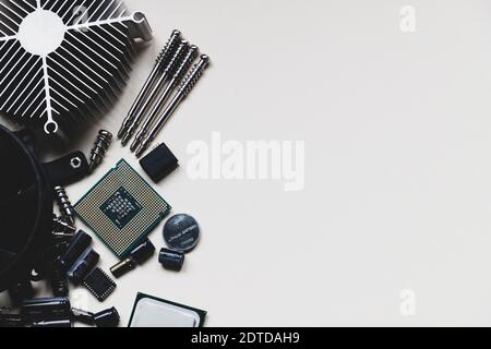 Computer and laptop hardware - CPU, fan cooler, battery, capacitors, radiator, chip on the white background with copy space, flat lay. PC parts top view. Repair, assembly, engineering concept. Stock Photo