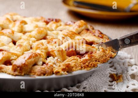 Cutting into a delicious home baked apple pie on the table. Stock Photo