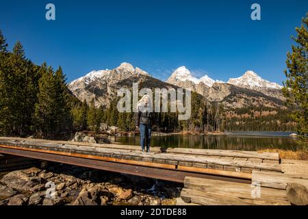 USA, Wyoming, Jackson, Grand Teton National Park, Senior woman standing by Taggart Lake in Grand Teton National Park Stock Photo