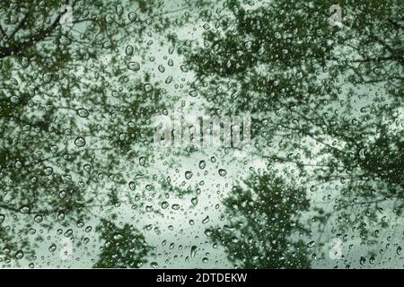 Raindrops on the window and blurred view outside the window. Raindrops on glass and defocused background. Stock Photo