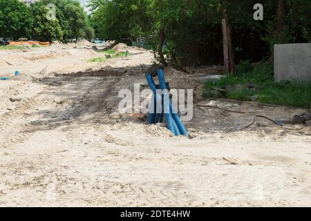 Laying of underground utilities. PVC corrugated hose for laying electric cables and fiber, Construction work on laying of communications Stock Photo