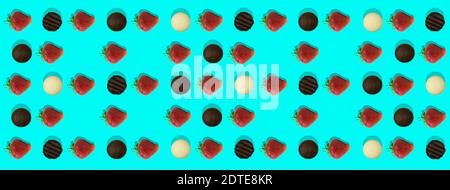 Background pattern strawberries and chocolate. Photo of strawberries and black chocolate and white chocolate evenly laid out on a turquoise background Stock Photo