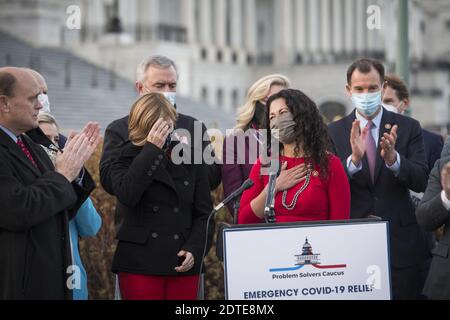 Washington, DC, USA. 21st Dec 2020. Problem Solvers Caucus Co-Chair United States Representative Tom Reed (Republican of New York), left, applauds United States Representative Xochitl Torres Small (Democrat of New Mexico), right, as they join members of the Problem Solvers Caucus for a press conference regarding the current stimulus bill, outside of the US Capitol in Washington, DC, USA, Monday, December 21, 2020. Photo by Rod Lamkey/CNP/ABACAPRESS.COM Credit: ABACAPRESS/Alamy Live News Stock Photo