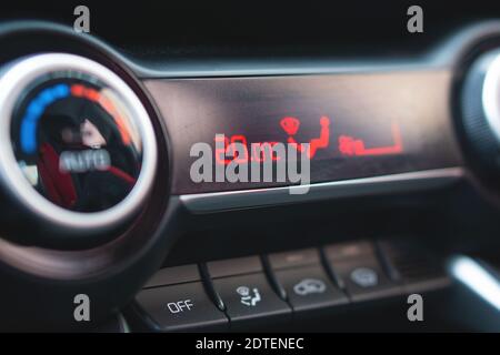 Closeup control buttons and display with temperature placed on dashboard inside contemporary car. Stock Photo