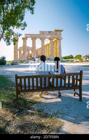 A couple visit Greek temples at Selinunte during vacation, View on sea and ruins of greek columns in Selinunte Archaeological Park Sicily Italy Stock Photo