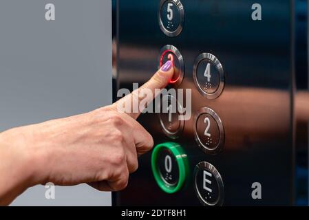 Finger pressing elevator button Stock Photo