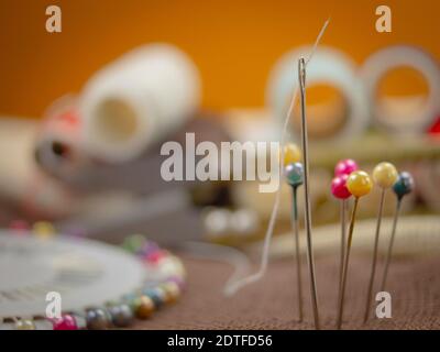 Thread in the ear of a needle. Background for text Stock Photo