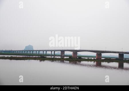 Cinematic dark and moody scenery of a bridge over the river in Ninh Binh, Vietnam Stock Photo