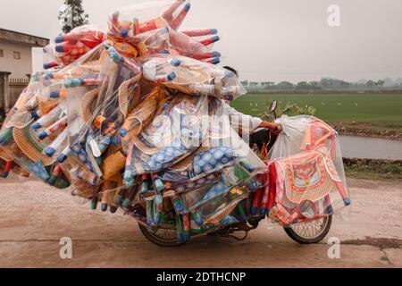 Vietnamese motorbike overloaded with cargo, shows the local culture and daily life in the countrysides of Vietnam Stock Photo