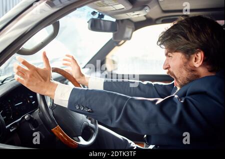 business man in a suit driving a car trip emotions official Stock Photo