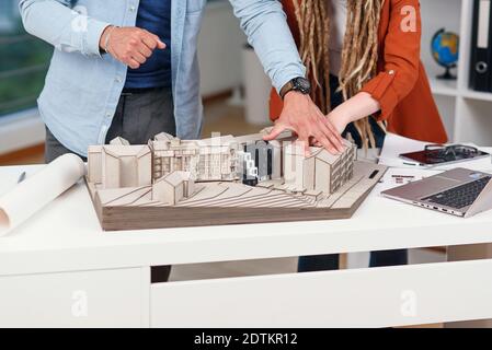 High-skilled creative male and female designers working with mock-up of future buildings Stock Photo