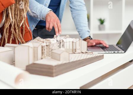 High-skilled creative male and female designers working with mock-up of future buildings Stock Photo