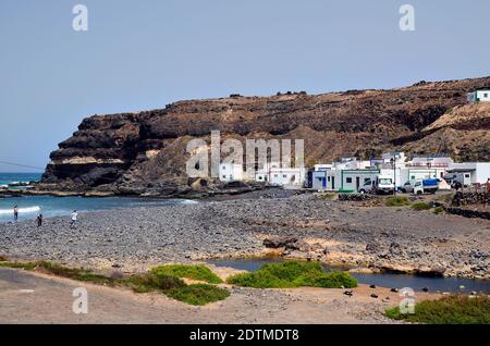 El Puerto de Los Molinos, Fuerteventura, Spain - April 01, 2017: Unidentified people on beach, restaurant and homes on west coast of the Canary island Stock Photo