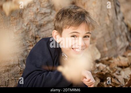 Autumn in the forest, boy under a tree Stock Photo