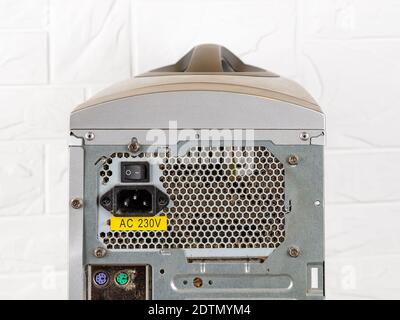 Rear view of tower computer case with dusty faulty power supply unit before replacement with a new one. Personal computer PSU installing, pc hardware. Stock Photo