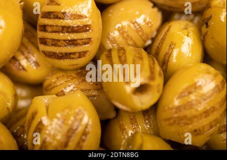 Green marinated olives, pitted, roasted on the grill. The texture of the surface. Close-up, selective focus Stock Photo