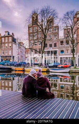 Amsterdam dutch canals , couple visit dutch canals during city trip in Amsterdam, men and woman on city trip in Amsterdam Netherlands. Europe Stock Photo