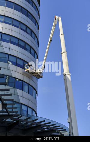 LEEDS, UNITED KINGDOM - Aug 08, 2020: Vertical shot of bridge water place building in leeds city centre with a crane in front with men cleaning window Stock Photo