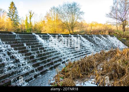 water tumbling down weir from lake in Trentham Gardens, Stoke on Trent Stock Photo