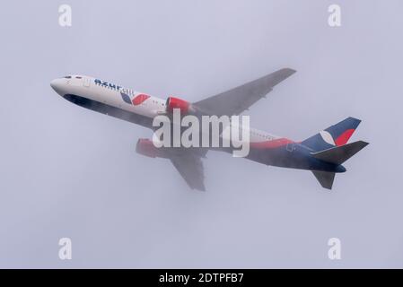 Departures are continuing from London Heathrow Airport as countries ban travel from UK, taking off into the very low overcast weather. Azur Air 767 Stock Photo