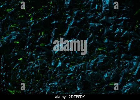 Dark Metal chrome foil texture drammatic effect with crumpled structure and bright lime sparkles. Polygonal dark background Stock Photo