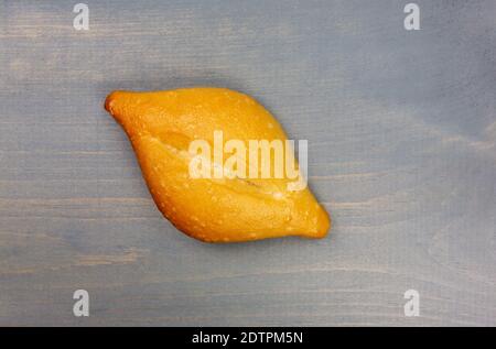 Top view of a single baked bolillo on a gray stained tabletop. Stock Photo