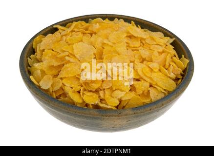Side view of a bowl of dry toasted corn cereal isolated on a white background. Stock Photo